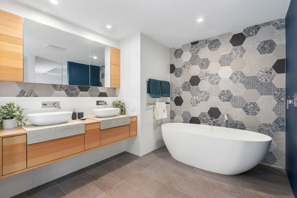Large bathroom with double vanity and a freestanding bath in front of a feature wall. This energy efficient renovation in Perth is showcasing some inspirational interior design.