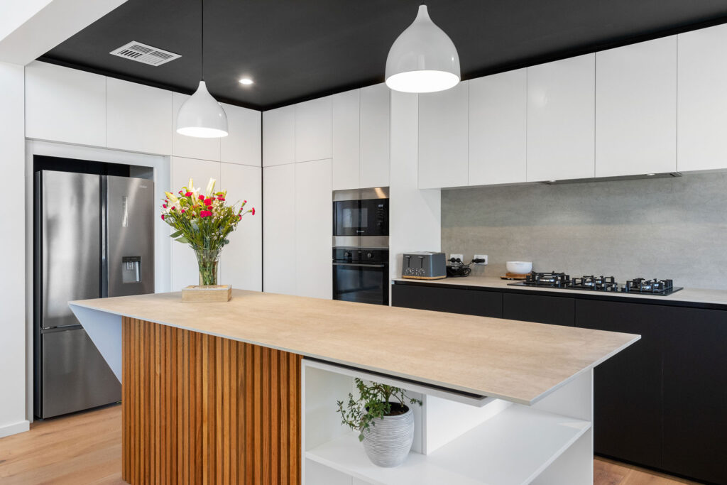 Black and white kitchen with a timber clad island a highlight in our latest energy efficient build in Perth.