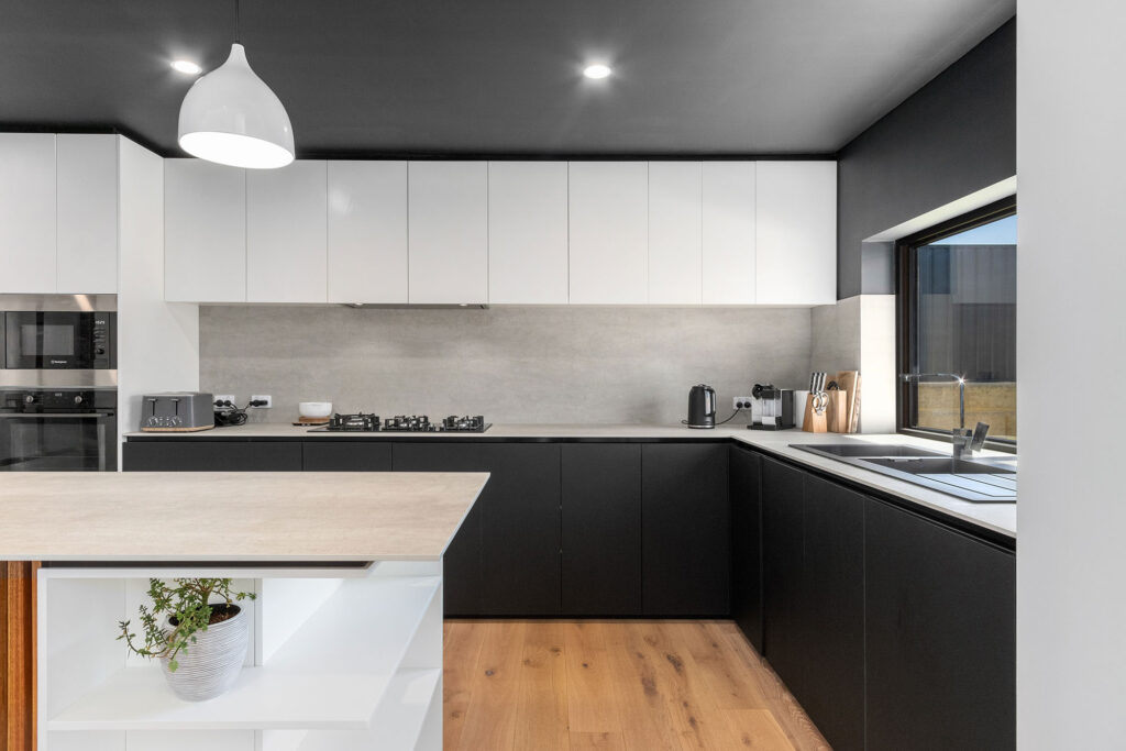 Modern black and white kitchen with a timber clad island, the heart of this sustainable architectural home built in Perth, WA.